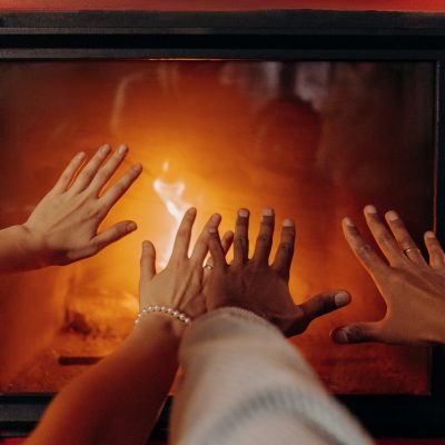 couples hands by fireplace